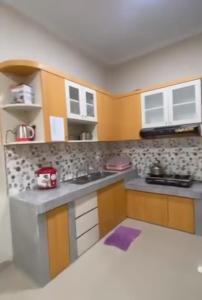um modelo de cozinha com armários amarelos e brancos em VILLA BRASTAGI SINABUNG VIEW em Berastagi