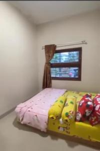 ein Schlafzimmer mit einem gelben Bett und einem Fenster in der Unterkunft VILLA BRASTAGI SINABUNG VIEW in Berastagi