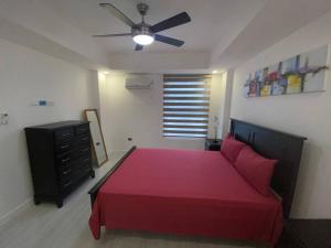 a bedroom with a red bed and a ceiling fan at The Echelon Suite in Kingston +15 photos