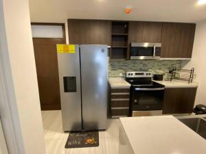 a kitchen with a stainless steel refrigerator and a stove at The Echelon Suite in Kingston