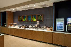 a buffet line in a hotel lobby with a television at SpringHill Suites by Marriott Mobile West in Mobile