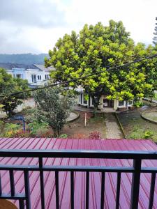 einen Balkon mit Blick auf ein Haus in der Unterkunft VILLA BRASTAGI SINABUNG VIEW in Berastagi