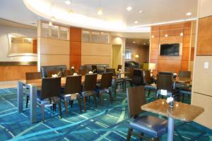 a dining room with tables and chairs and a television at SpringHill Suites Morgantown in Morgantown