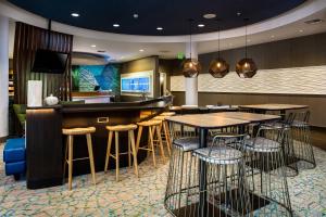 ein Restaurant mit Tischen und eine Bar in einem Zimmer in der Unterkunft SpringHill Suites Vero Beach in Vero Beach