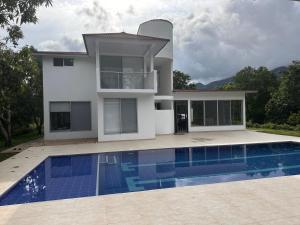 a house with a swimming pool in front of a house at Finca para estrenar in Anapoima