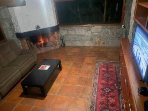 Casa verde في فالي دي برافو: غرفة معيشة مع أريكة ومدفأة