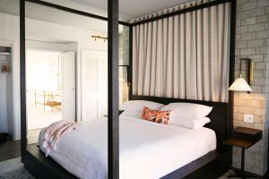 a bedroom with a large white bed and a mirror at The Alida, Savannah, a Tribute Portfolio Hotel in Savannah