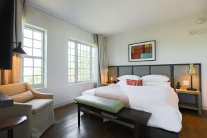 a bedroom with a large white bed and a couch at The Alida, Savannah, a Tribute Portfolio Hotel in Savannah