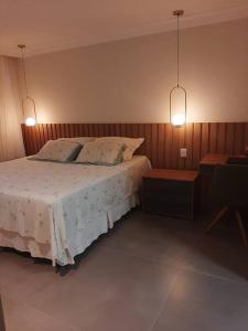 um quarto com uma cama com duas almofadas e duas luzes em Casa em Praia do Flamengo /Salvador-Ba em Salvador