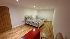 1 dormitorio con 2 camas y suelo de madera en Comfort Sleep, en Windsor
