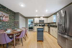 a kitchen and dining room with a table and a refrigerator at NEW Victorian Theme, 3BR, LRG Backyard close to PNC Arena, Downtown, and RDU Airport in Raleigh