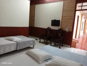 a bedroom with two beds and a flat screen tv at Hoa Lan Hotel in Bak Kan