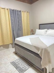 a bedroom with a large bed and yellow curtains at Paradise Vista in Bamboo Market