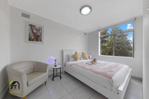 1 dormitorio con 1 cama, 1 silla y 1 ventana en Entire unit in Hurstville, en Sídney
