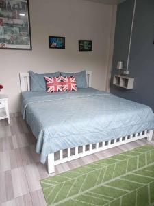 sypialnia z łóżkiem z niebieską pościelą i czerwonymi poduszkami w obiekcie Mountain View Guest House w mieście Phatthalung