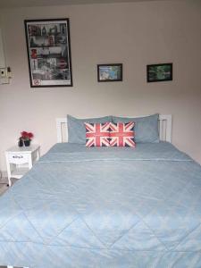 a bed with two british flag pillows on it at Mountain View Guest House in Phatthalung