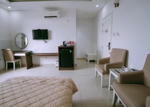 una camera con letto, tavolo e sedie di Thuan Phat House Soc Trang a Soc Trang