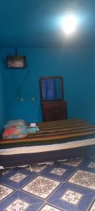1 dormitorio con cama y pared azul en Hotel y Restaurante Playa Linda en San Pedro La Laguna