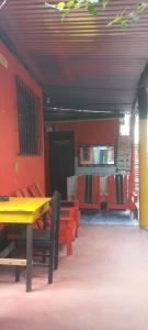 comedor con mesa amarilla y sillas rojas en Hotel y Restaurante Playa Linda, en San Pedro La Laguna