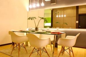 a dining room with a table and white chairs at The 21 Repoh Homestay in Kangar