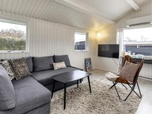 ein Wohnzimmer mit einem Sofa und einem Tisch in der Unterkunft Holiday home Karrebæksminde XXXIX in Karrebæksminde