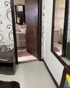 un baño con espejo y lavabo en Hostel quartos privados Ouvidor, en Garopaba