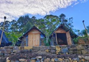 a house with a stone wall in front of it at Eco Lodge Haputale-Camping Sri lanka in Haputale