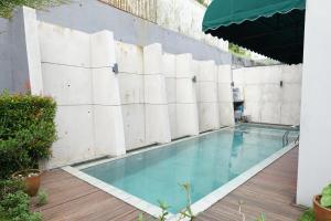 uma piscina num edifício com uma parede em Villa Majesty Dago em Bandung