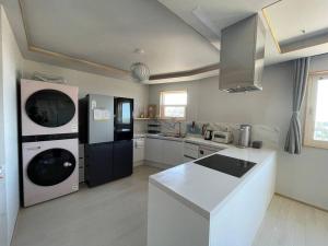 a kitchen with a black refrigerator and a white counter top at IMSTAY friendly child Eoeum Aewol in Jeju +17 photos