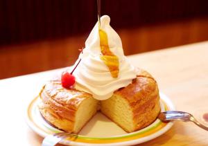 un morceau de gâteau sur une assiette avec de la crème fouettée dans l'établissement APA Hotel Shibuya Dogenzakaue, à Tokyo