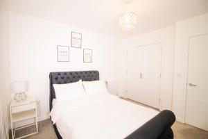 a white bedroom with a bed and a couch at Cosy 1Bedroom Apartment in Greenwich Cutty Sark in London