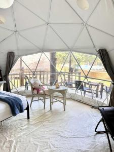 Balilihan的住宿－Eco Glamping Treehouses Closest Resort To All Tourist Attractions，带帐篷、床和桌子的客房