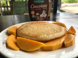 a white plate with a sandwich and bread and cantaloupe at Eden House & Coffee Con Dao in Con Dao