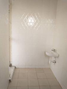 a white bathroom with a sink and a mirror at 4 BR/5 Bathroom Bungalow in Boma la Ngombe