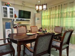 een eetkamer met een houten tafel en stoelen bij All Care Bed and Breakfast in Tagaytay