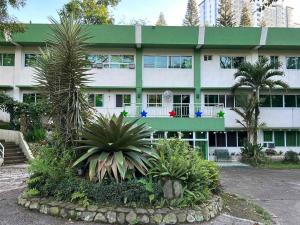 um edifício com um monte de plantas na frente dele em All Care Bed and Breakfast em Tagaytay