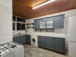 cocina con armarios azules y lavadora en Spitalfields Rooms, en Londres