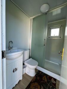 a small bathroom with a toilet and a shower at Maleka Farm: Tent Glamping North Shore Oahu in Laie