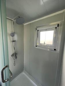 a bathroom with a shower and a window at Maleka Farm: Tent Glamping North Shore Oahu in Laie