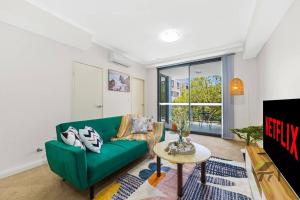 a living room with a green couch and a table at Wonderful Home in Your Heart in Waitara