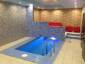 a swimming pool in a room with a tile wall at Power House Hotel in Lutsk