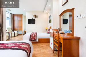 um quarto de hotel com duas camas e uma secretária em HANZ Queen Airport Hotel em Ho Chi Minh