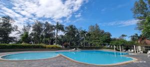 une grande piscine dans un parc arboré dans l'établissement VIP Condochain Rayong, à Ban Chamrung