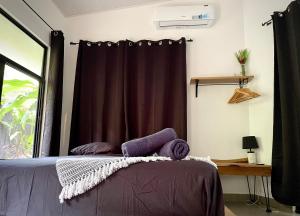 a bedroom with a bed with a purple curtain at Casa Eden - Modern Peaceful Jungle Apartments in Cocles