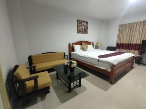 a bedroom with a bed and a couch and a table at The rich room ห้องพักนครราชสีมาใกล้เซ็นทรัล in Nakhon Ratchasima