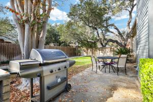 a barbecue grill and a table in a backyard at Nr Sea World Games Wifi Bbq Yard Pet Ok in San Antonio