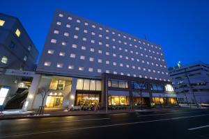 a large building on a city street at night at Kotoni Green Hotel in Sapporo