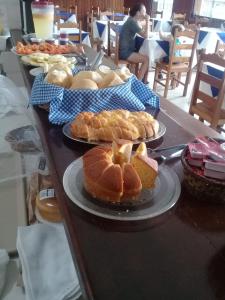 a table topped with plates of bread and pastries at Hotel Tres Meninos in Itariri