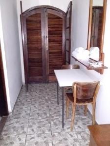 a room with a table and two chairs and a door at Hotel Tres Meninos in Itariri