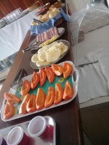 a table with two trays of oranges and other foods at Hotel Tres Meninos in Itariri